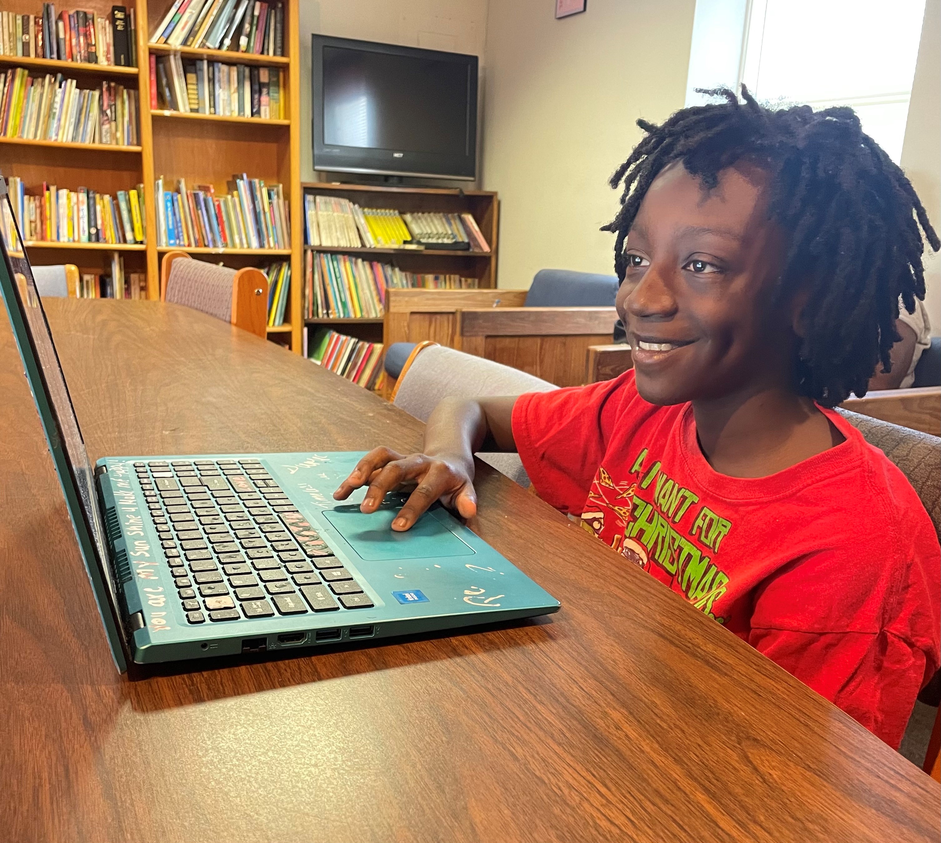 Child smiling while using a computer