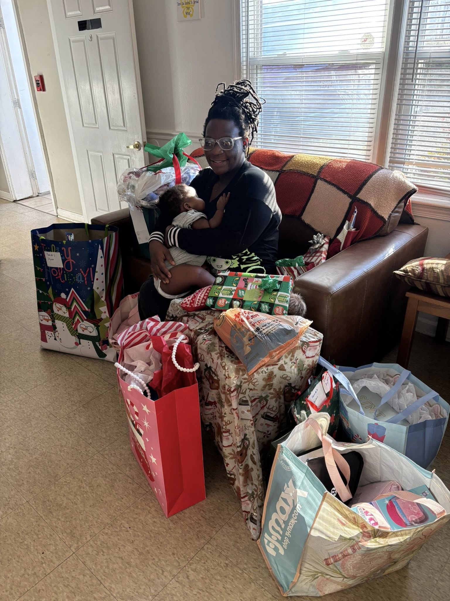 Parent and baby surrounded by donated gifts