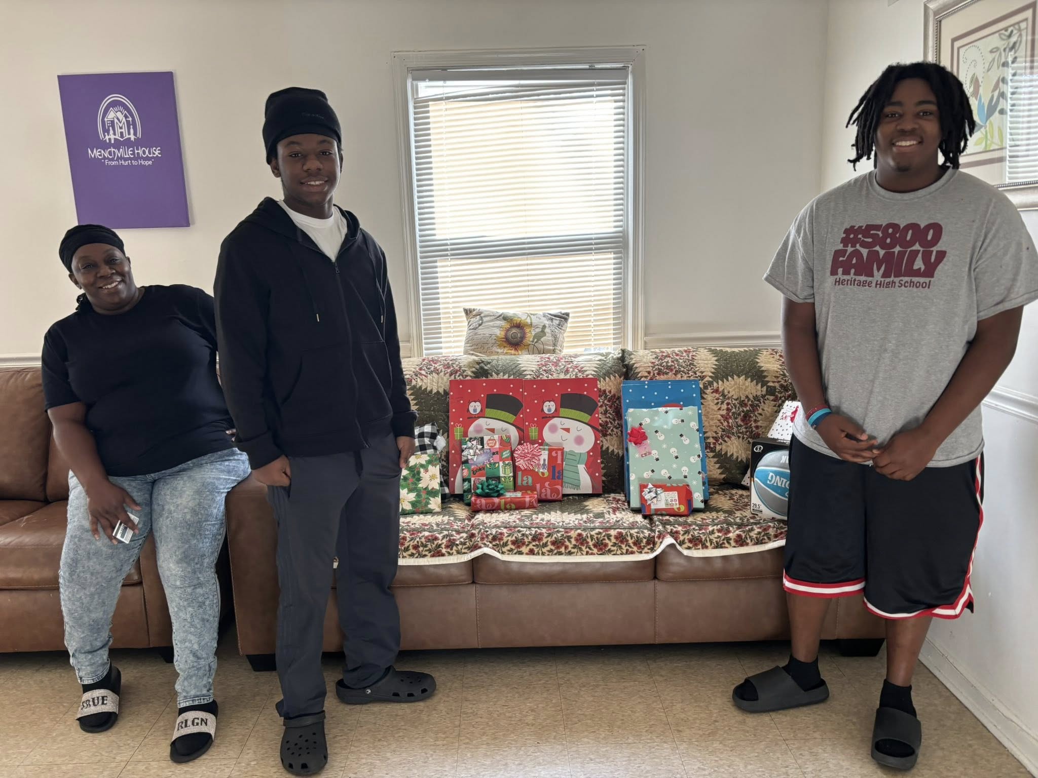 Children and a parent near donated holiday gifts